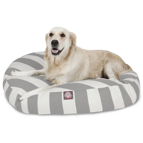 A golden retriever lies contentedly on a Majestic Pet Vertical Stripe Round Dog Bed with a removable cover, its mouth slightly open.