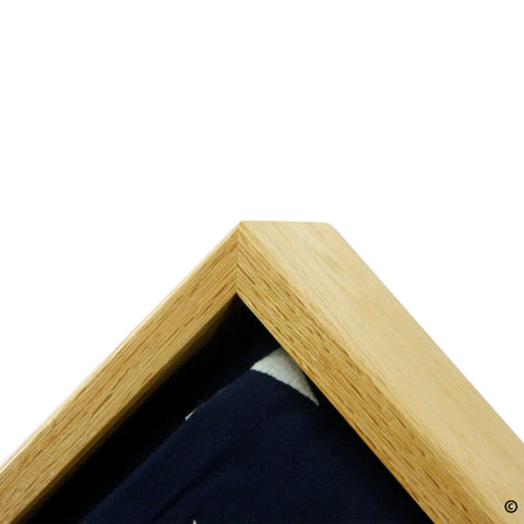 Close-up of Legacies of America Woodworking Companys Oak Burial Flag Display Case (for 5 x 9.5 flag), showing the light oak frame with a glass front and partial view of a dark blue item inside. Copyright in lower right. Made in the USA.