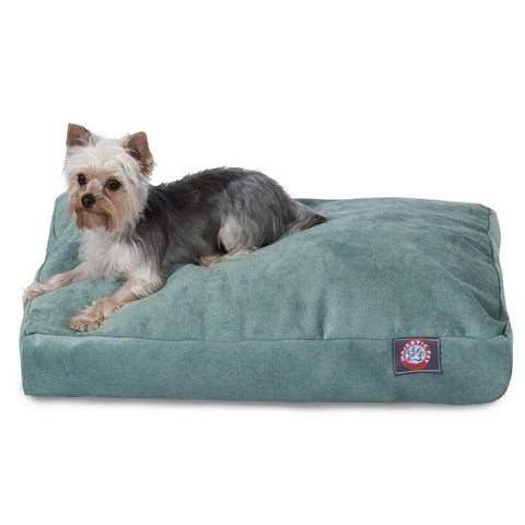 A small Yorkshire Terrier lies on a large, soft Villa Rectangle Dog Bed by Majestic Pet, filled with premium polyester fiber and featuring a logo patch in one corner.