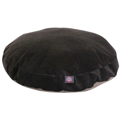 The Majestic Pet Villa Round Dog Bed is dark brown with a soft, velvety texture, a removable cover for easy cleaning, and features a small logo tag on the front edge.