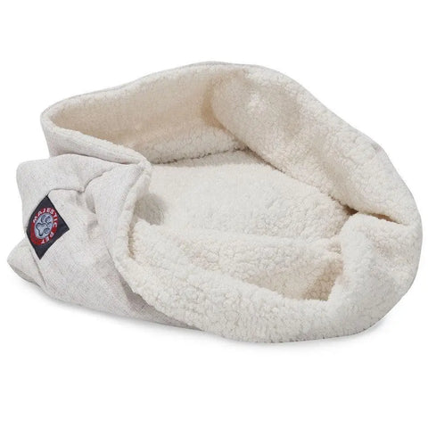 The Wales Burrow Cat Bed by Majestic Pet is a soft, cream-colored bed with a sherpa interior, light fabric exterior, raised edges, and an inviting open design for your pet’s comfort. Features a small patch with a circular logo.