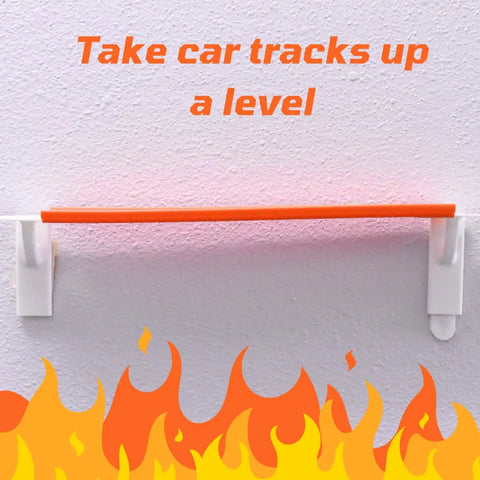 A single orange Toy Racetrack Wall Connector by Chatelet Manufacturing, compatible with Hot Wheels, is mounted horizontally on a white wall with two brackets and stylized flames, taking ramp racecar tracks up the wall. Made in USA.