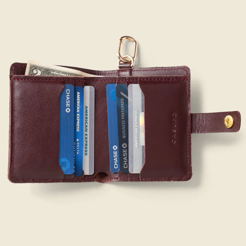 The CASUPO Wallet With Snap and Key Ring in burgundy is handcrafted from quality sustainable leather, featuring a snap closure, gold key ring, and organized slots for cash and credit cards including Chase and American Express.