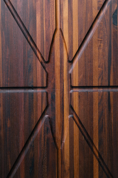 Close-up of The Oval Carver - Walnut by Montana Block, handcrafted in the USA with a geometric pattern on rich, dark walnut featuring lighter stripes and distinctive grain for a symmetrical, textured look.