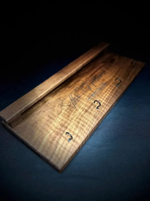 The Sunglasses and Key Rack by B. James Design & Woodwork features handcrafted walnut with a smooth finish, visible grain, and a signature inscription—perfect for stylish entryway organization.