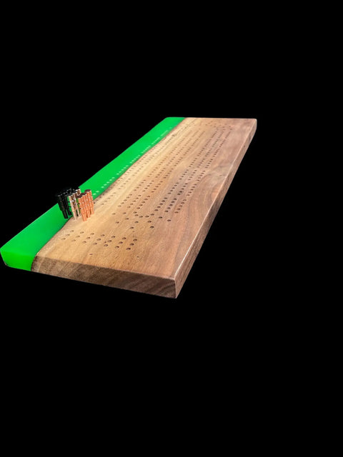The Lime Green Epoxy Walnut Cribbage Board by B. James Design & Woodwork features handcrafted quality, a vivid lime green epoxy accent, three metal pegs on the scoring track, and a solid black background.