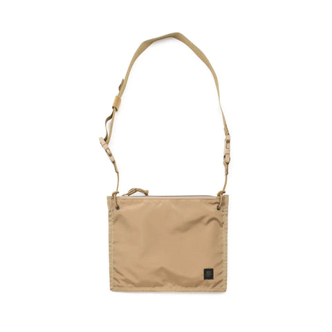The MIS 2 Way Pouch in Coyote Tan is a rectangular nylon shoulder bag with an adjustable strap, zippered top, black front label, and water-resistant minimalist design—ideal for carrying daily essentials.