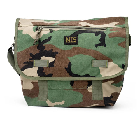 The MIS Messenger Bag - Woodland Camo features durable Cordura Nylon, a front zipper pocket, adjustable shoulder strap, and logo patch on the flap. Waterproof and made in the USA for lasting quality.