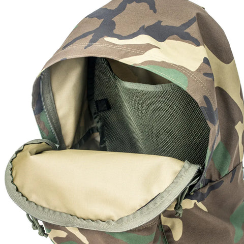 A close-up of the MIS Daypack Goretex in Woodland Camo shows the tan interior and mesh divider pocket inside its waterproof nylon main compartment.