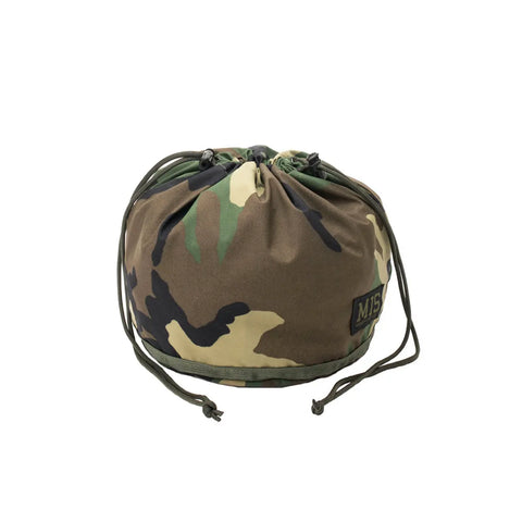 The MIS Personal Effects Bag - Woodland Camo is a round, camouflage-patterned drawstring pouch in green, brown, and tan. Made in the USA from waterproof breathable nylon, it features multiple drawstring cords and an MIS label on the front.