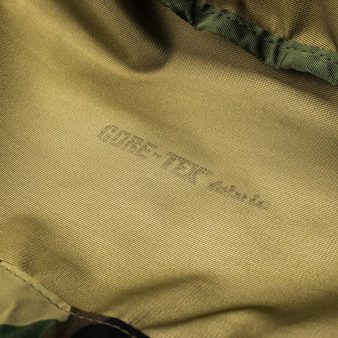 Close-up of the inside lining of the MIS Personal Effects Bag - Woodland Camo, showing faint “GORE-TEX” text on the light brown laminate. Texture, stitching, and waterproof breathable nylon are clearly visible.