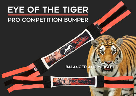 Two orange and black Bulletproof Pet Products Dock Diving Bumper Tug - Competition Series Weighted Eye of the Tiger toys are shown with a tiger and the words Balanced and Weighted—perfect for your energetic pup.