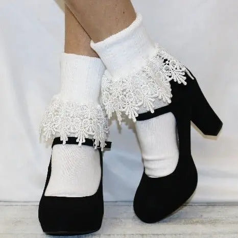Model wears black Mary Jane heels with Catherine Cole SIGNATURE Lace Cuff Socks in white, featuring elaborate lace trim at the cuffs, standing on a white background.