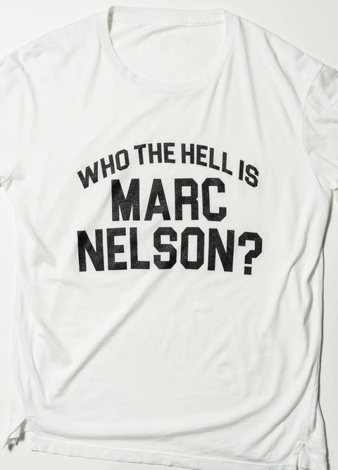 The Who the Hell? Tee by Marc Nelson is a classic-fit white T-shirt made from premium cotton, featuring bold black text: WHO THE HELL IS MARC NELSON? displayed on a light background.
