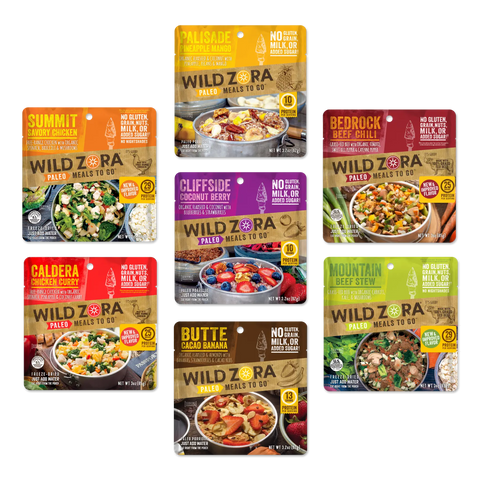 Wild Zora’s Meals to Go - All Flavors Variety 7-Pack showcases seven gluten-free, milk-free freeze-dried paleo meals with unique flavors like grass-fed beef, free-range chicken, curry, chili, berry banana, and stew.