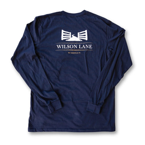 The Wilson Lane Apparel Graphic Tee Shirt - Long Sleeve is a navy blue, made-in-USA shirt featuring a white back graphic with two gates, the text “WILSON LANE,” and “EST NASHVILLE TN,” photographed flat on a white background.