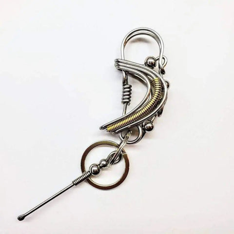 The Wire Coiled Birdie Keychain for Him by Alexa Martha Designs features intricate coils, loops, and spheres, resembling a sturdy keychain with a circular ring and straight pin, all set against a plain white background.