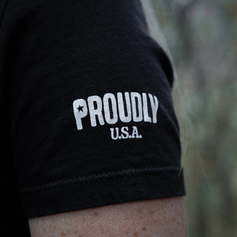Close-up of the Proudly USA American Flag - Womens Cotton T-Shirt (Black) sleeve with bold PROUDLY and U.S.A. prints and a star in the O—stylish, patriotic, and made in the USA.