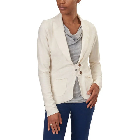 A woman models the Spiritex Lightweight Terry Tab Jacket in light beige over a gray top and dark blue pants—an ideal spring workwear look from Spiritex | Sustainable Apparel, set against a plain white background.