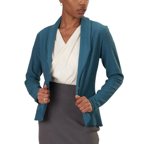 A woman models the Spiritex Lightweight Terry Tab Jacket in teal—made from organic cotton—over a white blouse and high-waisted gray skirt against a white background; the perfect sustainable spring workwear look.