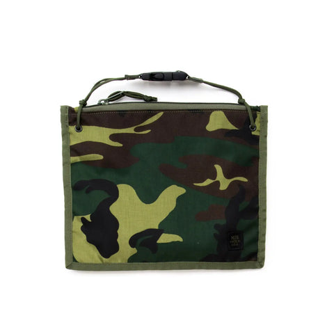 The MIS 2 Way Pouch - Woodland Camo is a rectangular, water-resistant pouch with zipper closure, green cord handle, and a small black label—ideal as a tablet clutch.