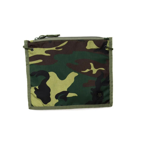 The MIS 2 Way Pouch - Woodland Camo is a rectangular, zippered, water-resistant pouch with a green, brown, and black camo pattern, small black label at the bottom right, and green side loops—ideal for use as a tablet clutch.