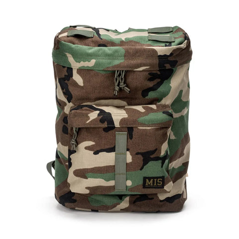 The MIS Backpack - Woodland Camo features Cordura Nylon, a padded laptop holder, green straps, and an MIS label on the front pocket, shown against a white background.