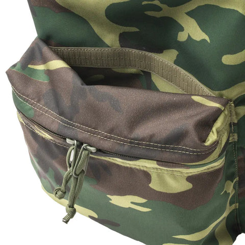 A close-up of the MIS Daypack - Woodland Camo highlights the front zippered pocket and part of the main compartment above, showcasing its green and brown nylon design.