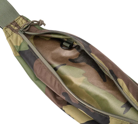 A close-up of the open zippered pocket on the MIS Body Bag - Woodland Camo shows its interior lining and a small black key ring clip inside; made in the USA from camouflage-patterned packcloth nylon.