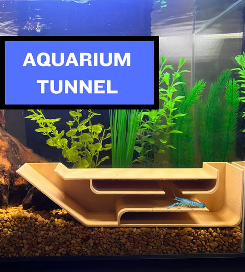 Rectangular aquarium with green plants, gravel, and the Chatelet REEFSHAPE Aquarium X-Large Underground Tunnel by Chatelet Manufacturing at the bottom. Blue crayfish near entrance. Large text box reads “AQUARIUM TUNNEL” in white on blue.