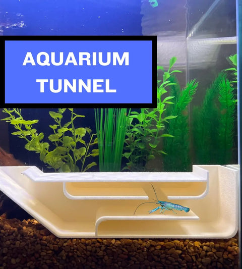 An aquarium with green plants and a Chatelet REEFSHAPE XL Underground Tunnel at the bottom, featuring a blue crayfish inside. A blue box labeled AQUARIUM TUNNEL is overlaid at the top left. Brand: Chatelet Manufacturing.