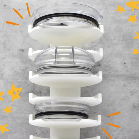 Close-up of Chatelet Manufacturing’s Yeti Lid Mount Rack holding three clear round lids, mounted vertically on a gray wall with orange stars and lines—ideal kitchen storage for easy access and organization.