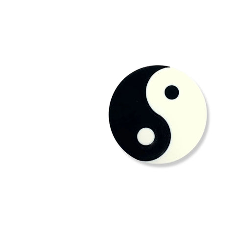 A black and white BOGLETS Yin and Yang Charm by Chatelet Manufacturing, compatible with Bogg Bags, Simply Southern, and similar totes, rests slightly right of center on a plain white background.
