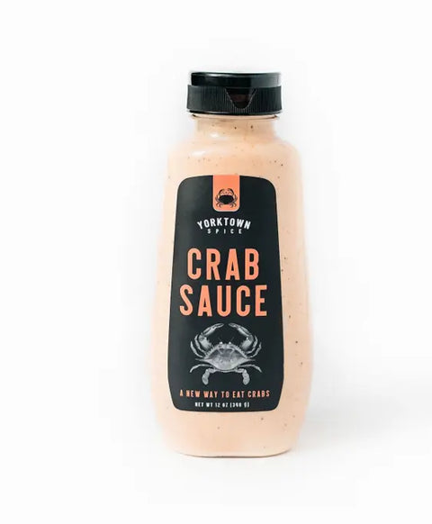 A bottle of Yorktown Spice Crab Sauce, featuring a black label with orange text and a crab illustration, is shown against a plain white background.
