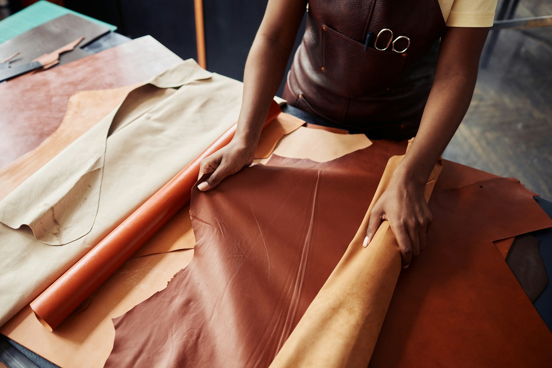 Person working with leather on a table