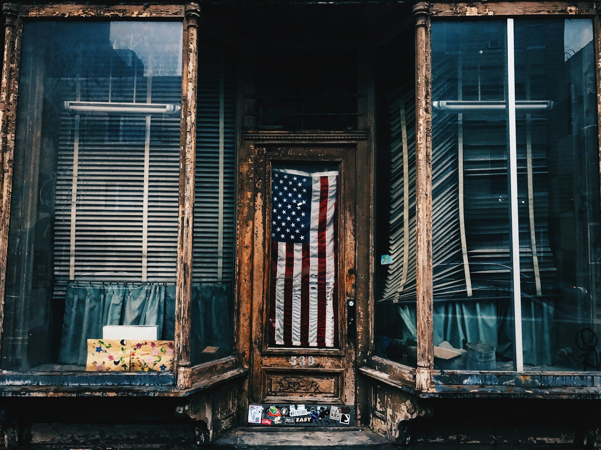 American flag hanging in a window of an old building