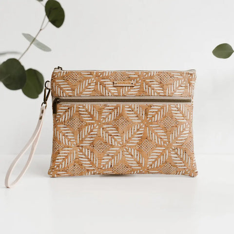 The INVENTOR tablet organizer | CREAM by Carry Courage is a cream vegan cork organizer with a geometric leaf pattern, front zipper pocket, and wrist strap, shown against a white background with green leaves at the edges.