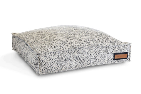 The Houndry Lounger Pet Bed in Sapphire Spaniel features a square, textured, washable design with a gray and white diamond pattern and a small brown leather tag—perfect as a stylish dog lounger.