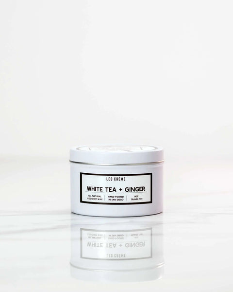 A Les Creme White Tea + Ginger Scent Coconut Wax Candle sits on a white marble surface with a plain light background. This candle is simple, modern, and crafted for a clean, toxin-free burn.